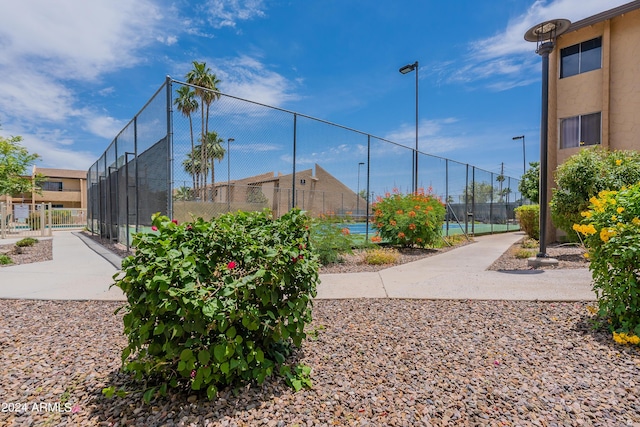 view of property's community featuring tennis court