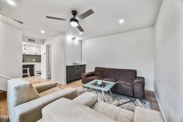 living room with ceiling fan and light hardwood / wood-style floors