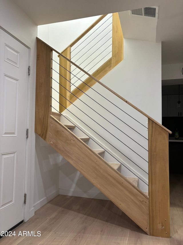 staircase with hardwood / wood-style floors