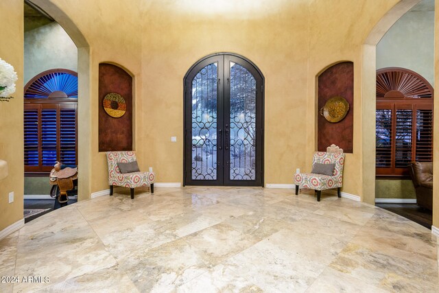 foyer entrance with french doors, a high ceiling, and tile floors