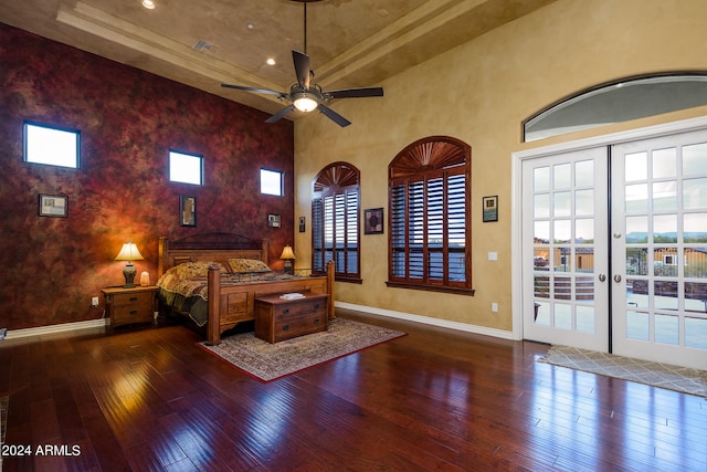 unfurnished bedroom with french doors, dark wood-type flooring, and a tray ceiling