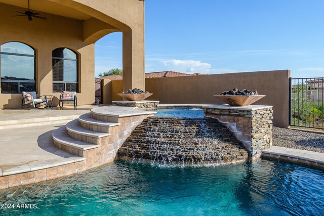 view of pool with a patio, ceiling fan, and pool water feature