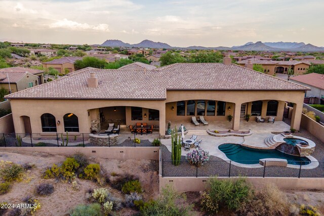 back of house featuring a fenced in pool, a patio, a mountain view, and an outdoor living space