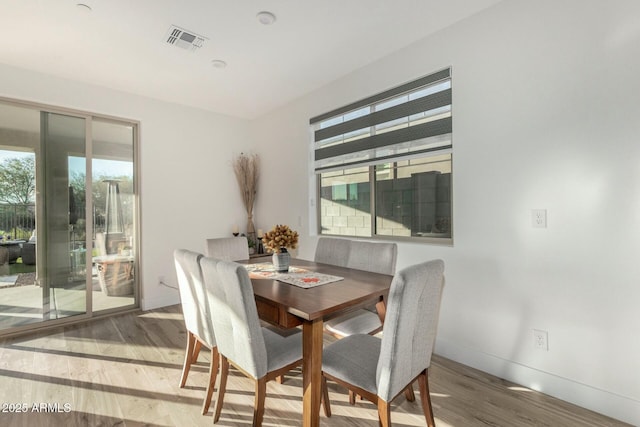 dining room with hardwood / wood-style flooring and a healthy amount of sunlight