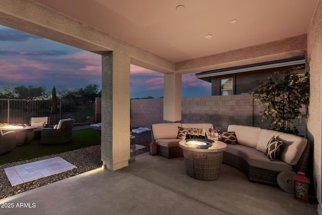 patio terrace at dusk featuring an outdoor living space with a fire pit