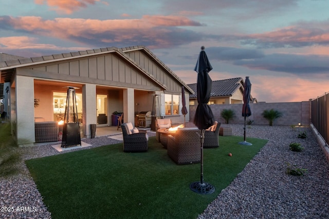 back house at dusk featuring an outdoor fire pit and a patio area