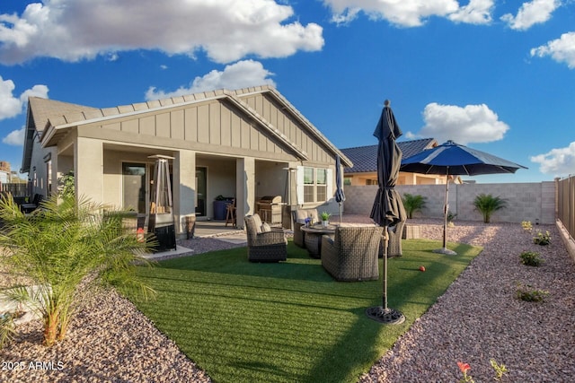 rear view of house featuring outdoor lounge area, a lawn, and a patio area