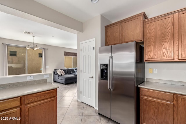 9148 W Meadow Dr, Peoria, AZ 85382 - kitchen featuring stainless steel refrigerator with ice dispenser, brown cabinetry, light tile patterned floors, decorative light fixtures, and open floor plan