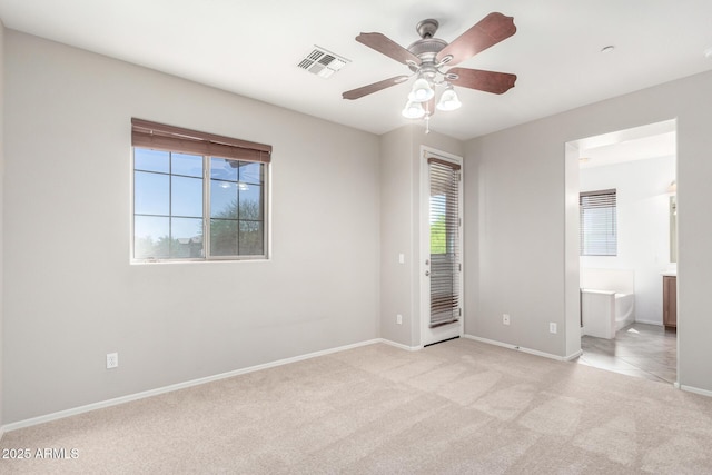 9148 W Meadow Dr, Peoria, AZ 85382 - unfurnished bedroom featuring multiple windows, light colored carpet, baseboards, and connected bathroom