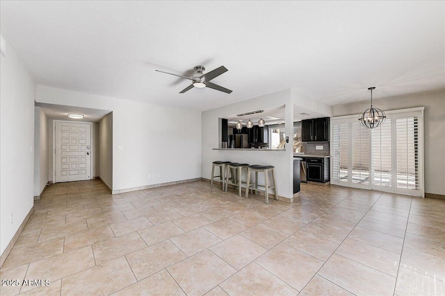 unfurnished living room featuring light tile patterned floors and ceiling fan with notable chandelier