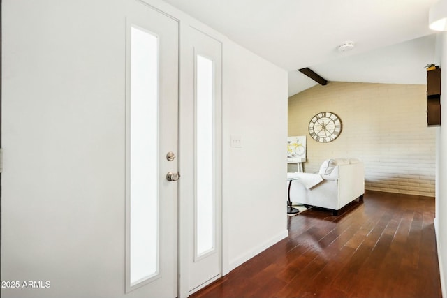 foyer with dark hardwood / wood-style flooring, lofted ceiling with beams, and brick wall