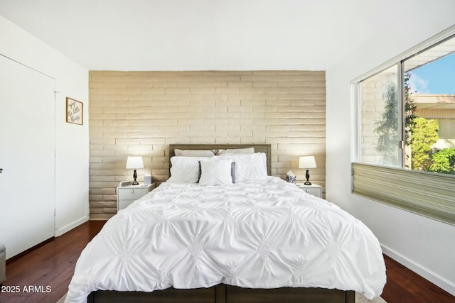 bedroom featuring dark hardwood / wood-style flooring and multiple windows