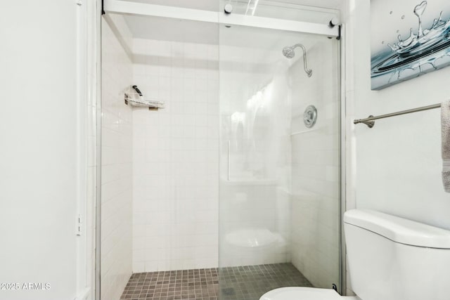 bathroom with a shower with door and toilet