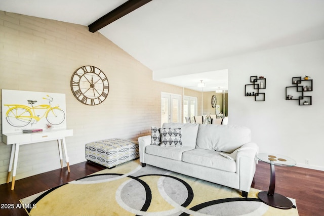 living room featuring lofted ceiling with beams, brick wall, and hardwood / wood-style flooring