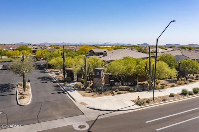 view of road featuring sidewalks, street lighting, a residential view, and a mountain view