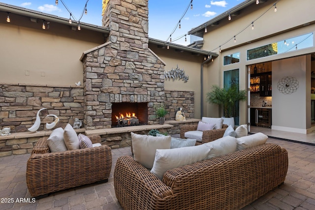 view of patio featuring wine cooler and an outdoor living space with a fireplace