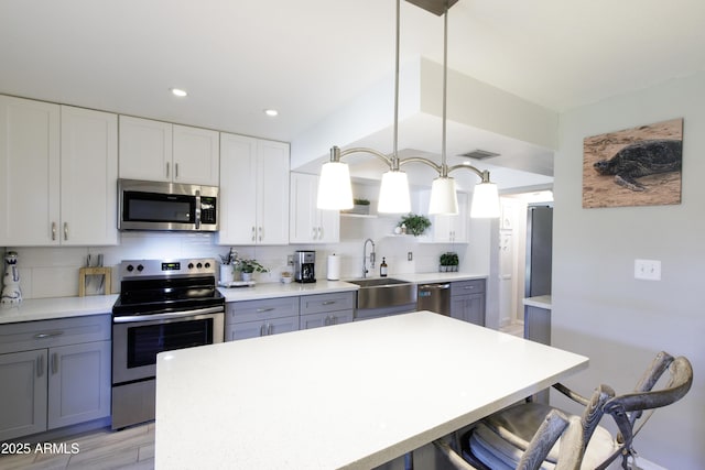 8135 N Central Ave Unit 1, Phoenix, AZ 85020 - kitchen featuring appliances with stainless steel finishes, a kitchen bar, a sink, open shelves, and backsplash