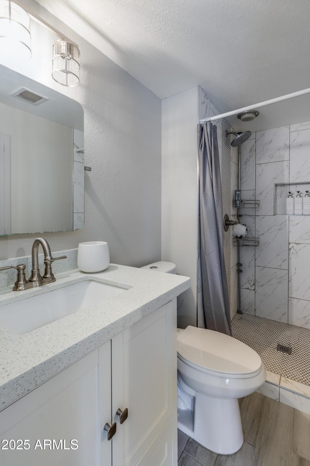 8135 N Central Ave Unit 1, Phoenix, AZ 85020 - bathroom with vanity, toilet, a stall shower, wood finished floors, and a textured ceiling
