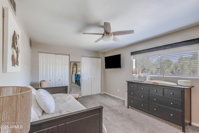 8135 N Central Ave Unit 1, Phoenix, AZ 85020 - bedroom featuring multiple closets, light colored carpet, baseboards, and a ceiling fan