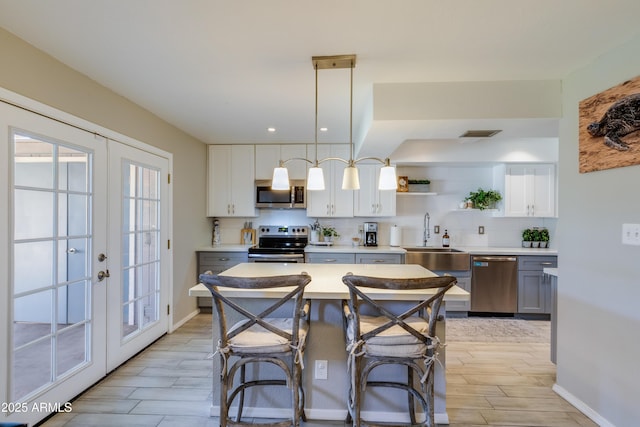 8135 N Central Ave Unit 1, Phoenix, AZ 85020 - kitchen featuring stainless steel appliances, wood finish floors, open shelves, light countertops, and recessed lighting