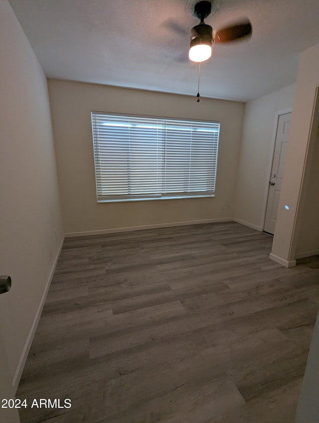 unfurnished room featuring ceiling fan and dark hardwood / wood-style flooring