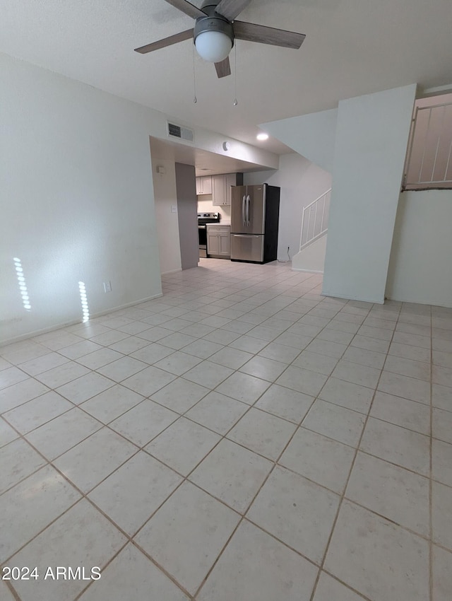 unfurnished living room featuring light tile patterned floors and ceiling fan