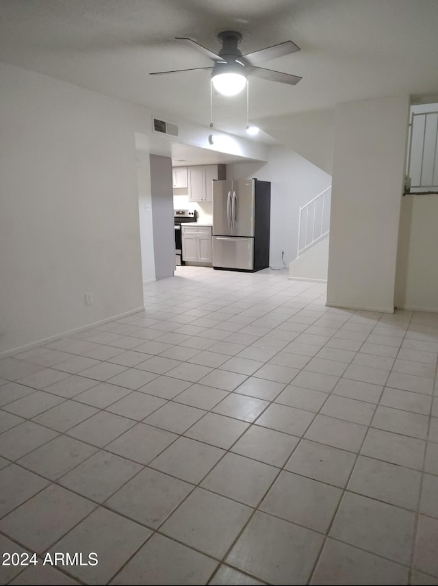 unfurnished living room featuring ceiling fan and light tile patterned flooring