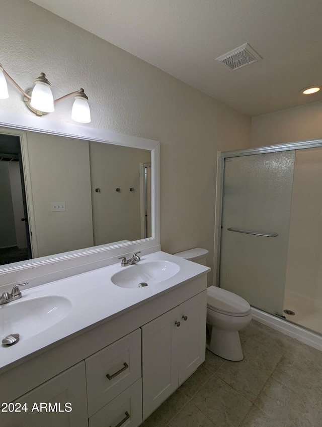 bathroom featuring vanity, toilet, and a shower with door