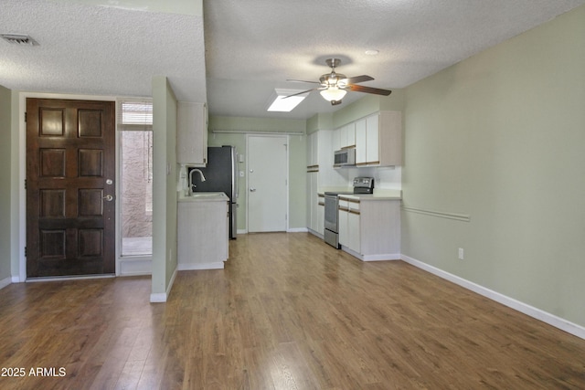 3345 E University Dr Unit 2, Mesa, AZ 85213 - kitchen featuring stainless steel appliances, ceiling fan, wood finished floors, light countertops, and white cabinets