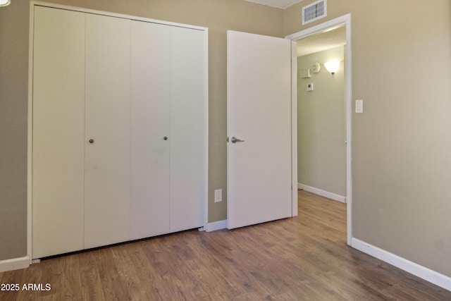 3345 E University Dr Unit 2, Mesa, AZ 85213 - unfurnished bedroom featuring a closet and wood finished floors