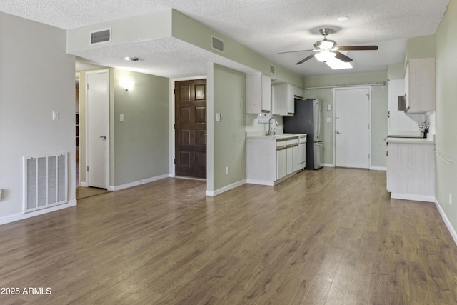 3345 E University Dr Unit 2, Mesa, AZ 85213 - kitchen featuring freestanding refrigerator, ceiling fan, a textured ceiling, wood finished floors, and white cabinets