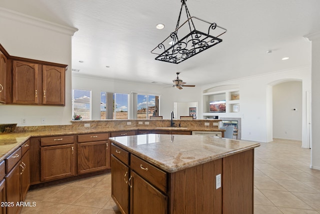 kitchen featuring ceiling fan, sink, light tile patterned floors, crown molding, and a kitchen island