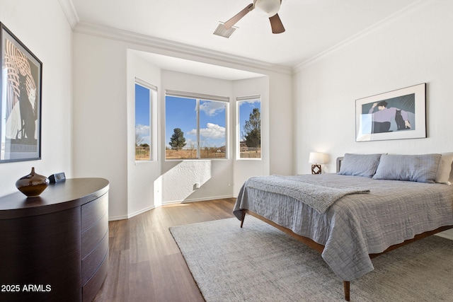 bedroom featuring ceiling fan, crown molding, and hardwood / wood-style flooring