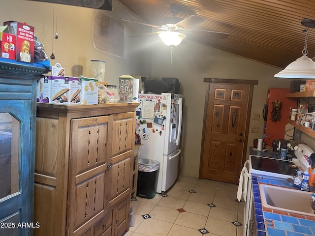 kitchen with lofted ceiling, light tile patterned floors, ceiling fan, white fridge with ice dispenser, and decorative light fixtures