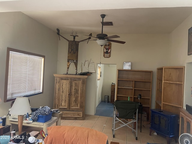 interior space featuring ceiling fan and a wood stove