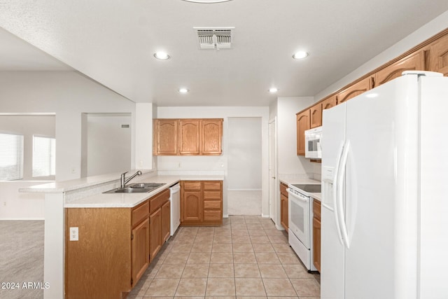 kitchen featuring light colored carpet, sink, white appliances, and kitchen peninsula