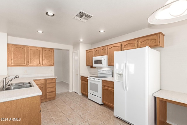 kitchen with sink, light tile patterned flooring, and white appliances