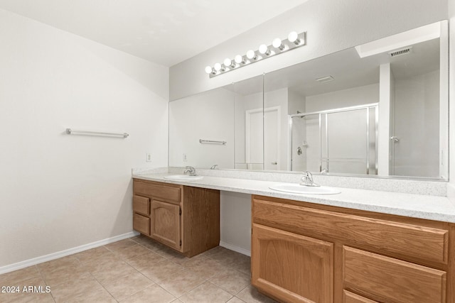 bathroom featuring vanity, tile patterned floors, and a shower with door