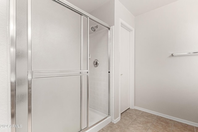 bathroom with tile patterned flooring and walk in shower