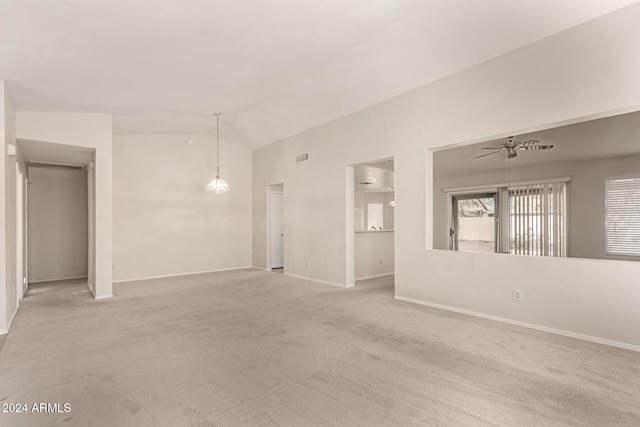 carpeted spare room with ceiling fan and vaulted ceiling