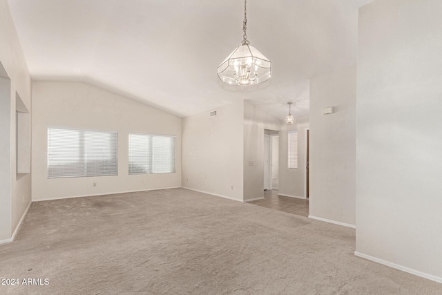 empty room with light carpet, lofted ceiling, and a notable chandelier