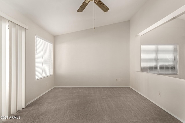 carpeted spare room featuring ceiling fan and lofted ceiling