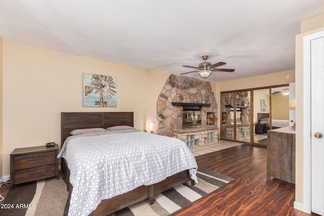 bedroom with a closet, hardwood / wood-style flooring, a fireplace, and ceiling fan