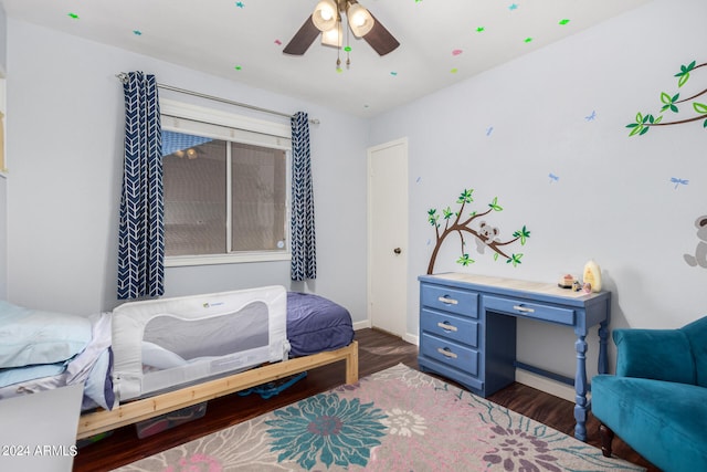 bedroom with dark hardwood / wood-style flooring and ceiling fan