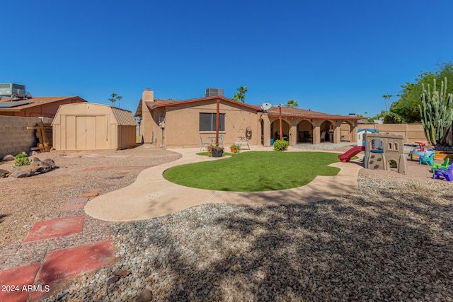 back of property with a patio, a storage shed, and central AC