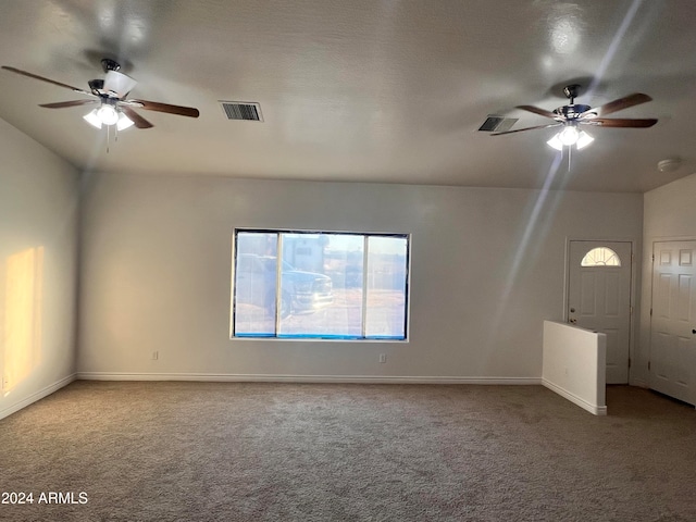 unfurnished living room featuring ceiling fan, a textured ceiling, and carpet