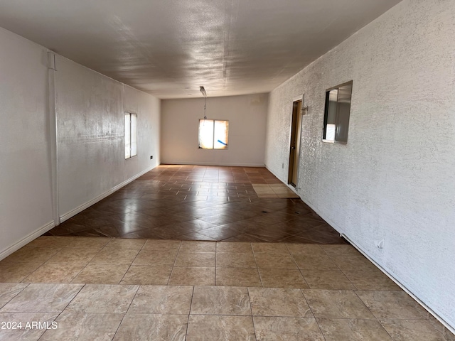 spare room featuring tile patterned flooring and lofted ceiling