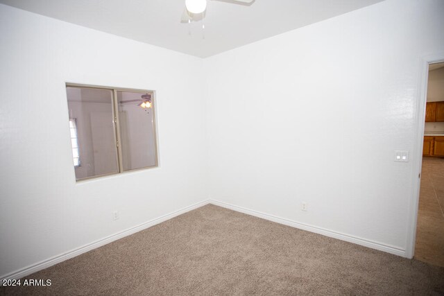 carpeted spare room with ceiling fan