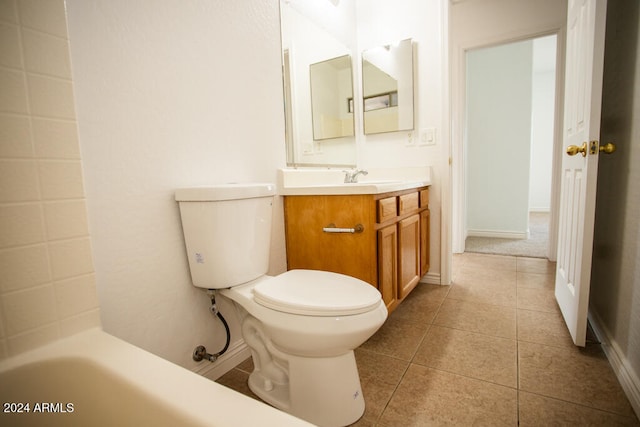 bathroom with a washtub, vanity, tile patterned floors, and toilet