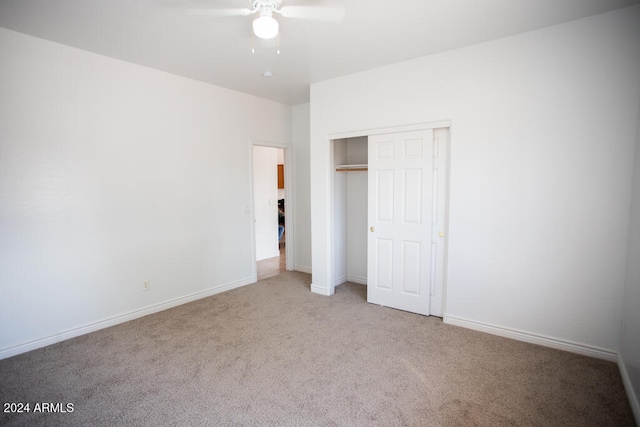 unfurnished bedroom with a closet, light carpet, and ceiling fan